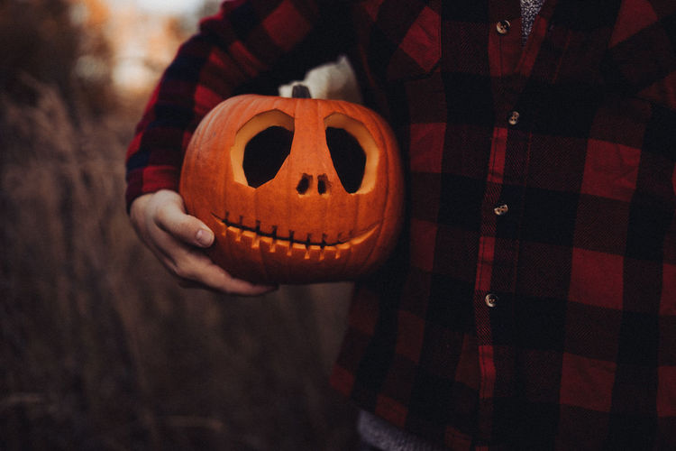 Human hand holding pumpkin