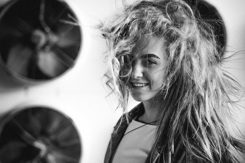 Portrait of teenage girl standing against exhaust fans