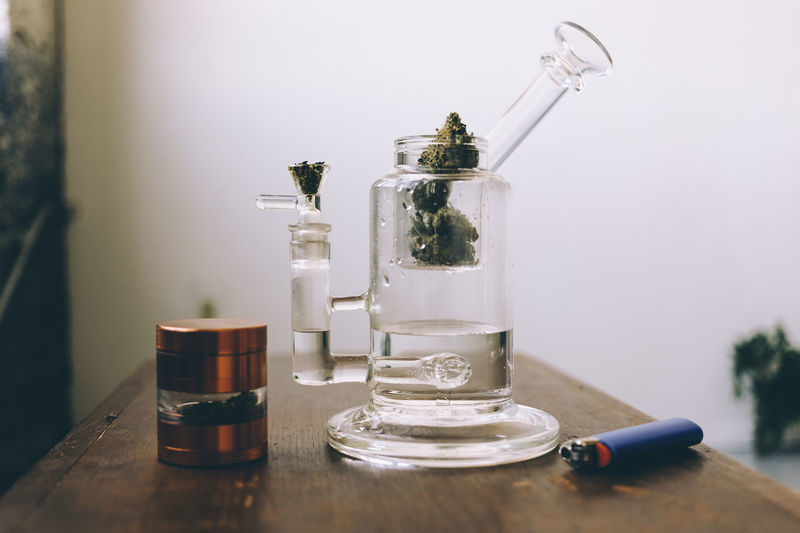 Close-up of on cannabis plant and grinder on table