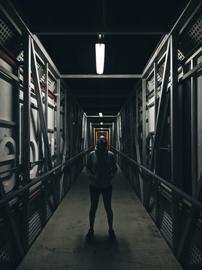 Rear view of man walking on footbridge