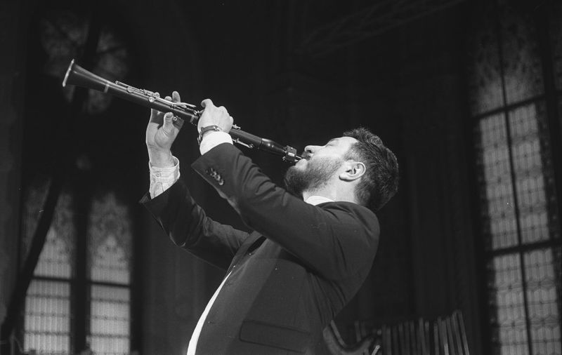 Man playing clarinet while standing at studio