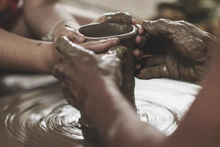 Close-up of hands working on pottery wheel
