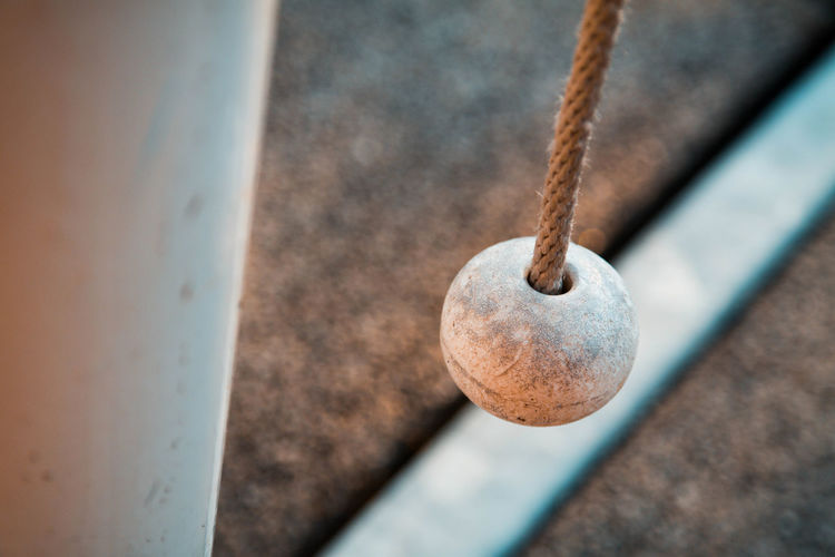 High angle view of metal hanging on rope against wall