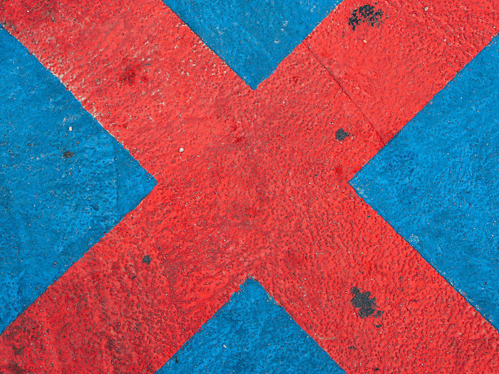 Close-up of red cross shape on wall