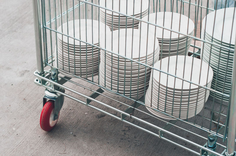 Clean white plates in a metal cart.