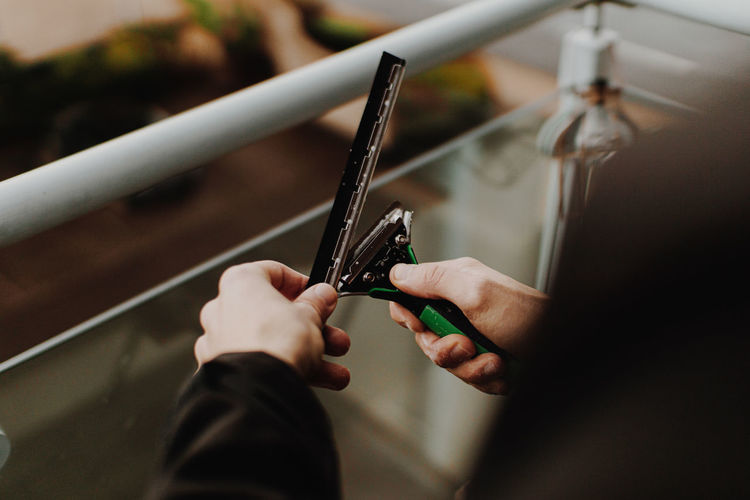 Midsection of cleaner holding blade outdoors