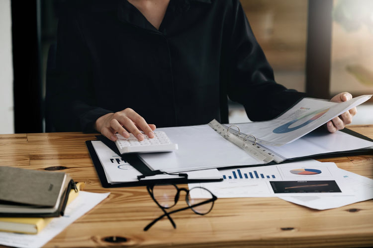 Midsection of businesswoman working on table