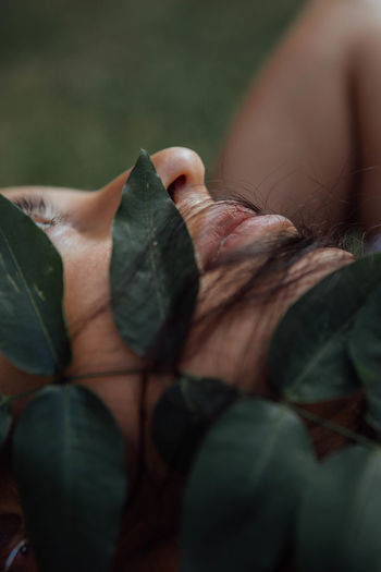 CLOSE-UP OF WOMAN WITH LEAVES