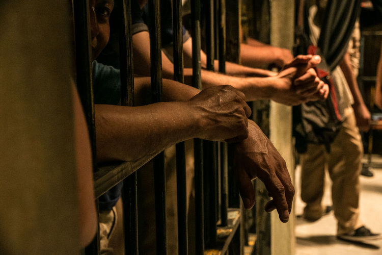 Two men's hand inside a prision