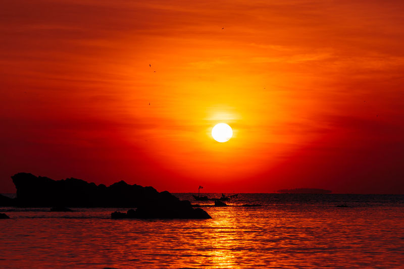 Scenic view of sea against romantic sky at sunset