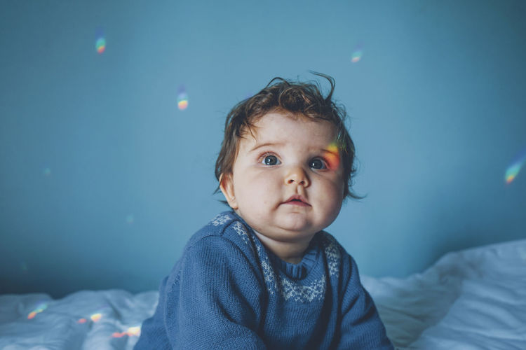 Cute baby girl on bed at home