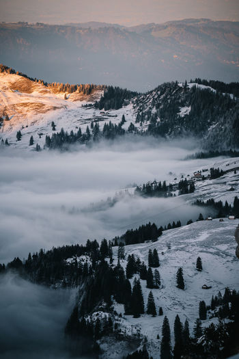 Scenic view of snow covered mountains against sky during sunset