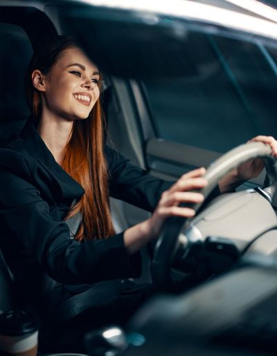Portrait of young woman sitting in car