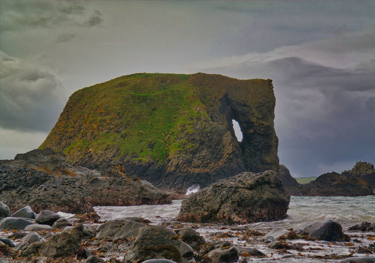 Rock formations by sea against sky