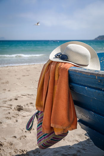 Hooded chair on beach against sea