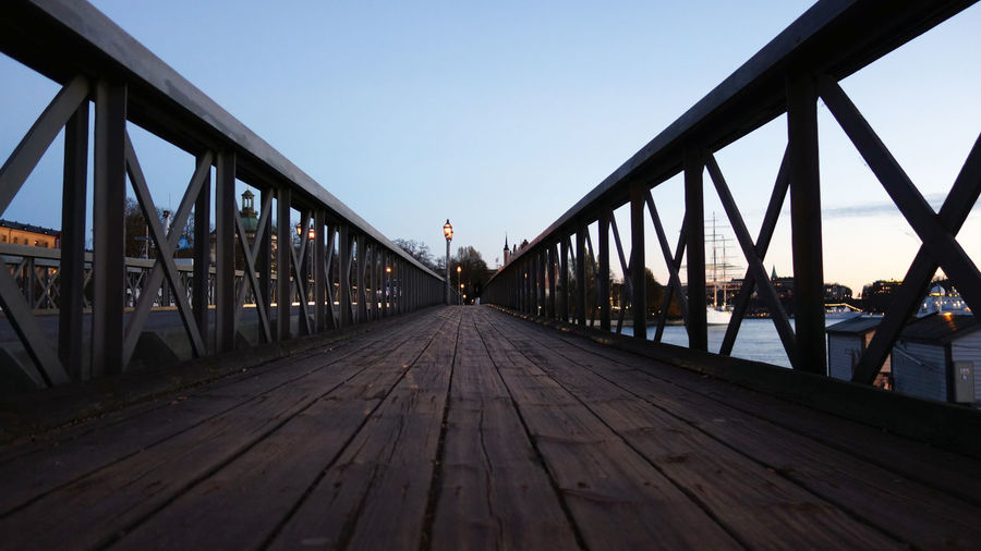 Footbridge over pier against clear sky