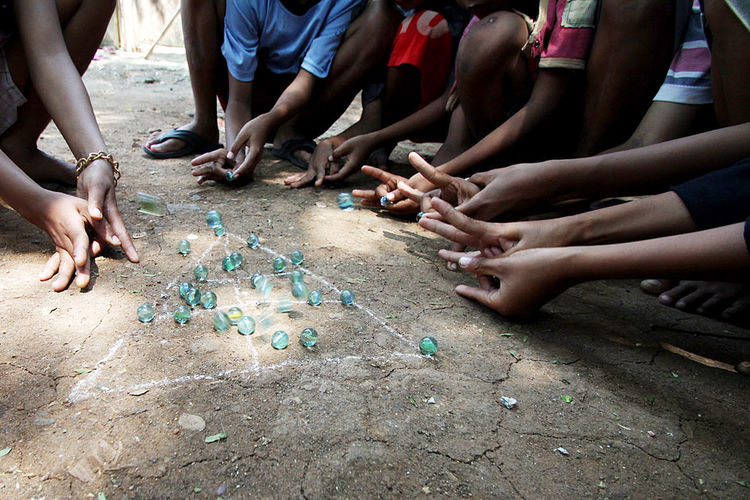 A number of children play a traditional game of marbles in tangerang city, banten.