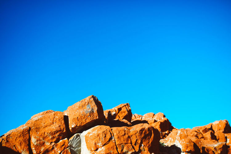 Low angle view of rock formation against clear blue sky