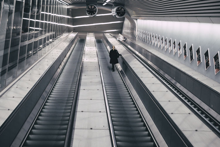 Woman standing on escalator