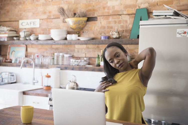 Businesswoman stretching while working at home
