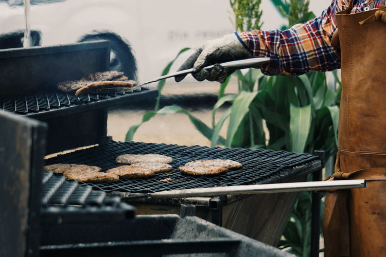 Midsection man preparing food on barbecue grill