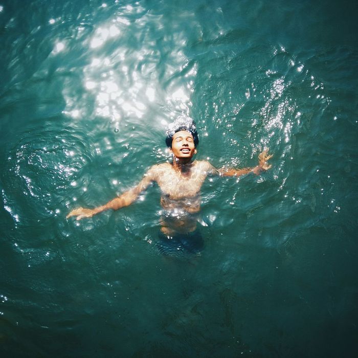 High angle view of shirtless young man swimming in sea