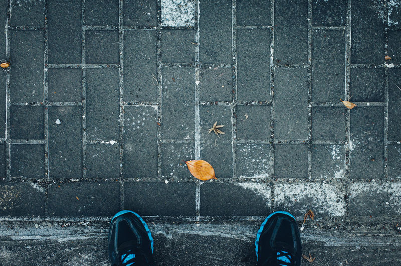 Autumn leaf on the tiled floor / looking down own foot - pov shot