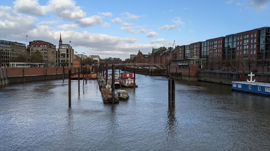 Bridge over canal in city against sky