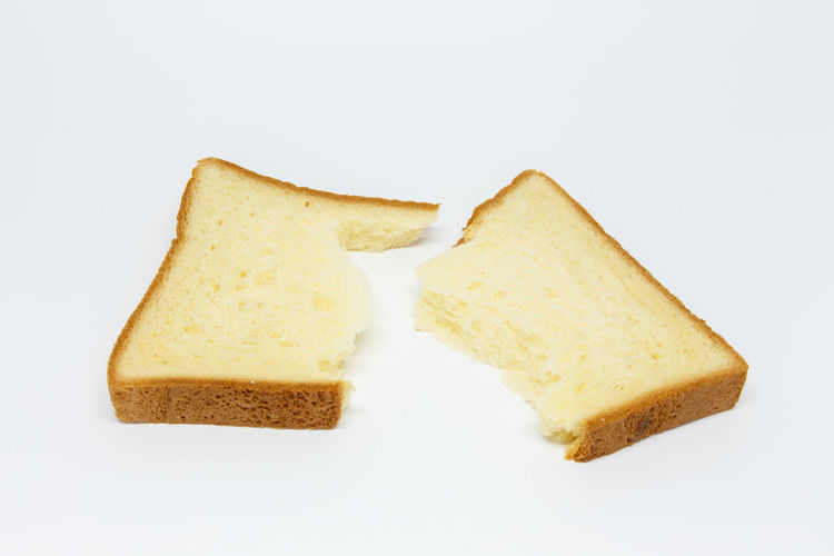 Close-up of bread in plate against white background