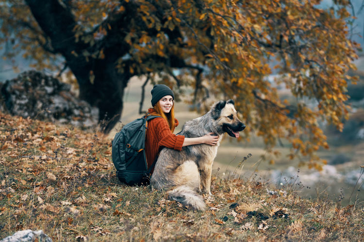 Woman sitting with dog on grass