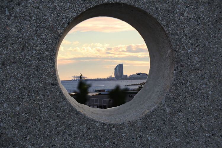 Buildings seen through hole at sunset