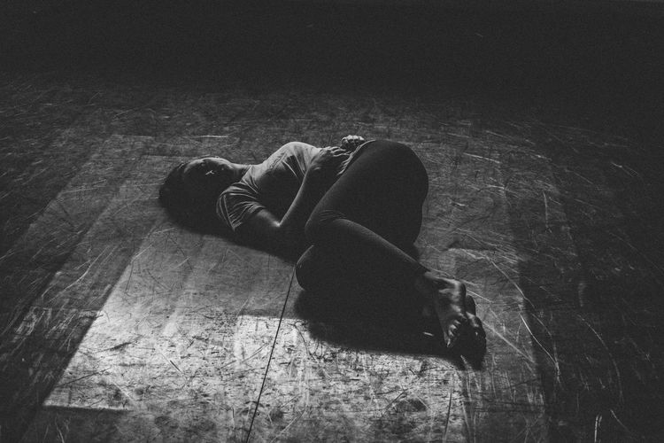 Full length of sad woman lying down on floor