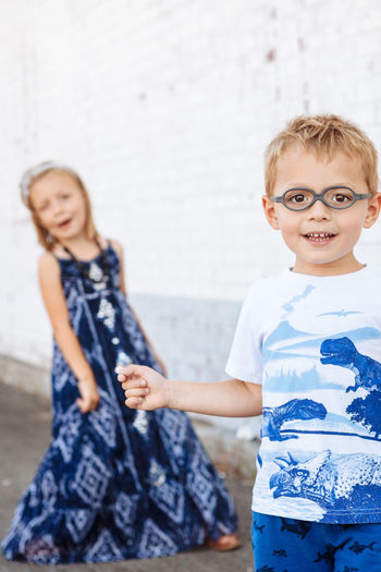 Portrait of smiling boy standing against blue wall