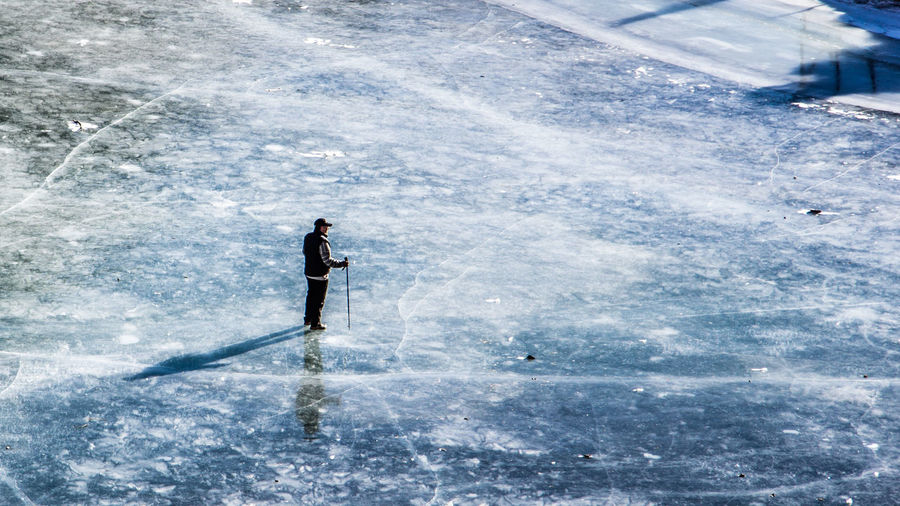 High angle view of person standing on an iced lake