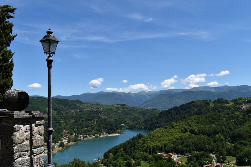 Street by river and mountains against sky