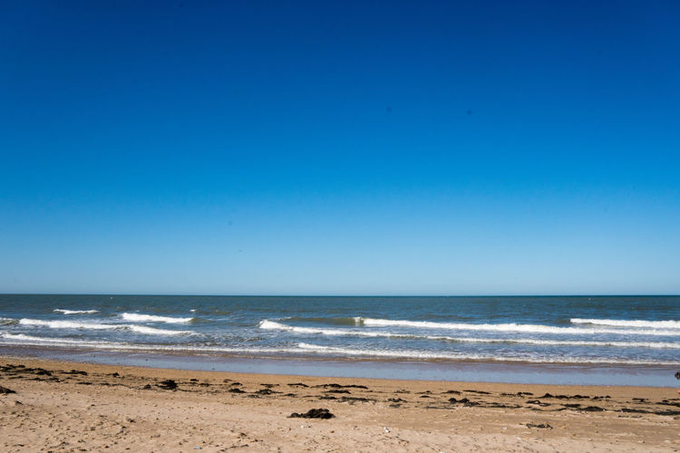 Scenic view of sea against clear blue sky