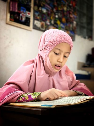 A girl sitting and reciting the holy quran