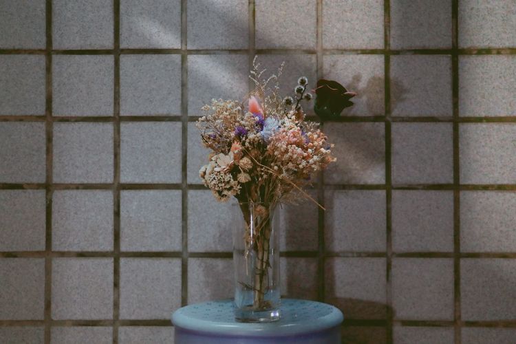 Flower vase on floor against wall at home