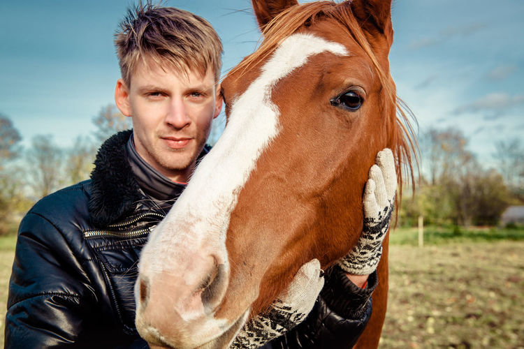 Portrait of smiling young man with horse