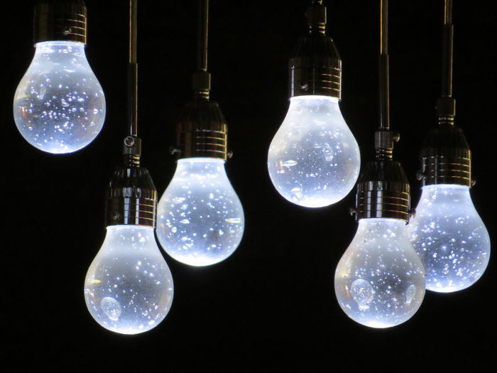 Close-up of illuminated electric bulbs against black background