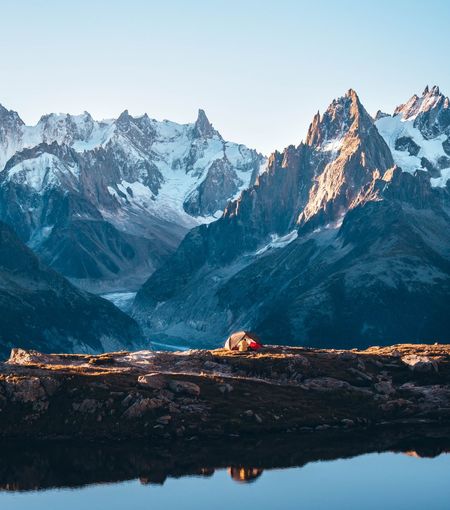 Scenic view of snowcapped and tent mountains against sky