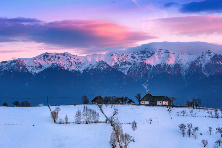Scenic view of snowcapped mountains against sky during sunset