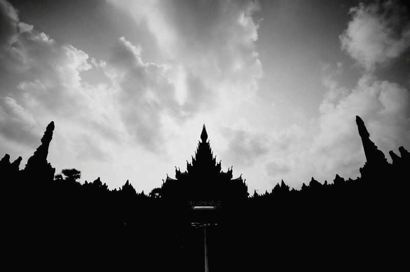 Low angle view of silhouette temple against sky