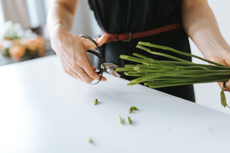 florist is cutting a bouquet of flowers for a customer Business Entrepreneur Woman Work Working Arrangement Bouquet Cutting Female Florist Flower Shop Flowers Freshness Green Color Hand Holding Human Body Part Human Hand Indoors Job Lifestyles One Person Preparation Real People Table