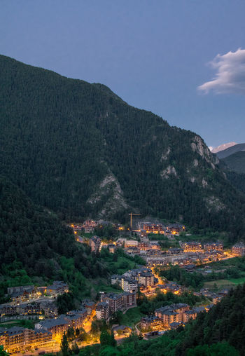 Aerial view of town by mountain against sky