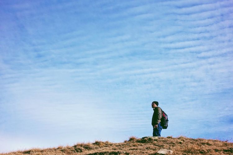 Man standing on field against sky