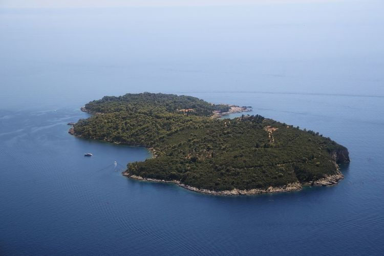 High angle view of island amidst sea against sky