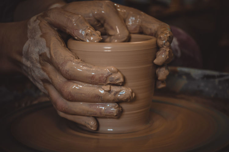 Close-up of human hand in mud
