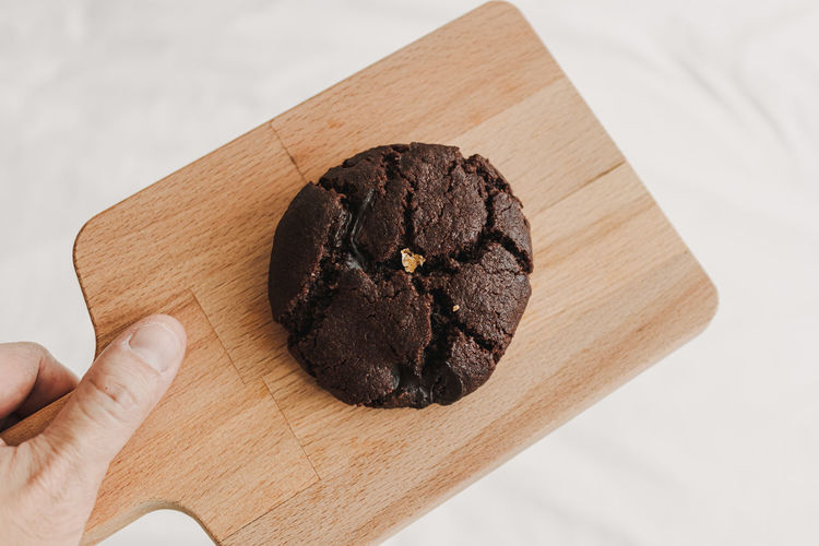 Homemade big chewy soft chocolate cookie with gold leaf.