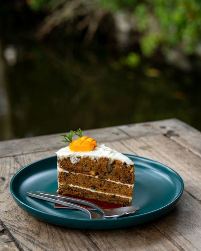 Carrot cake on a plate on a wooden table